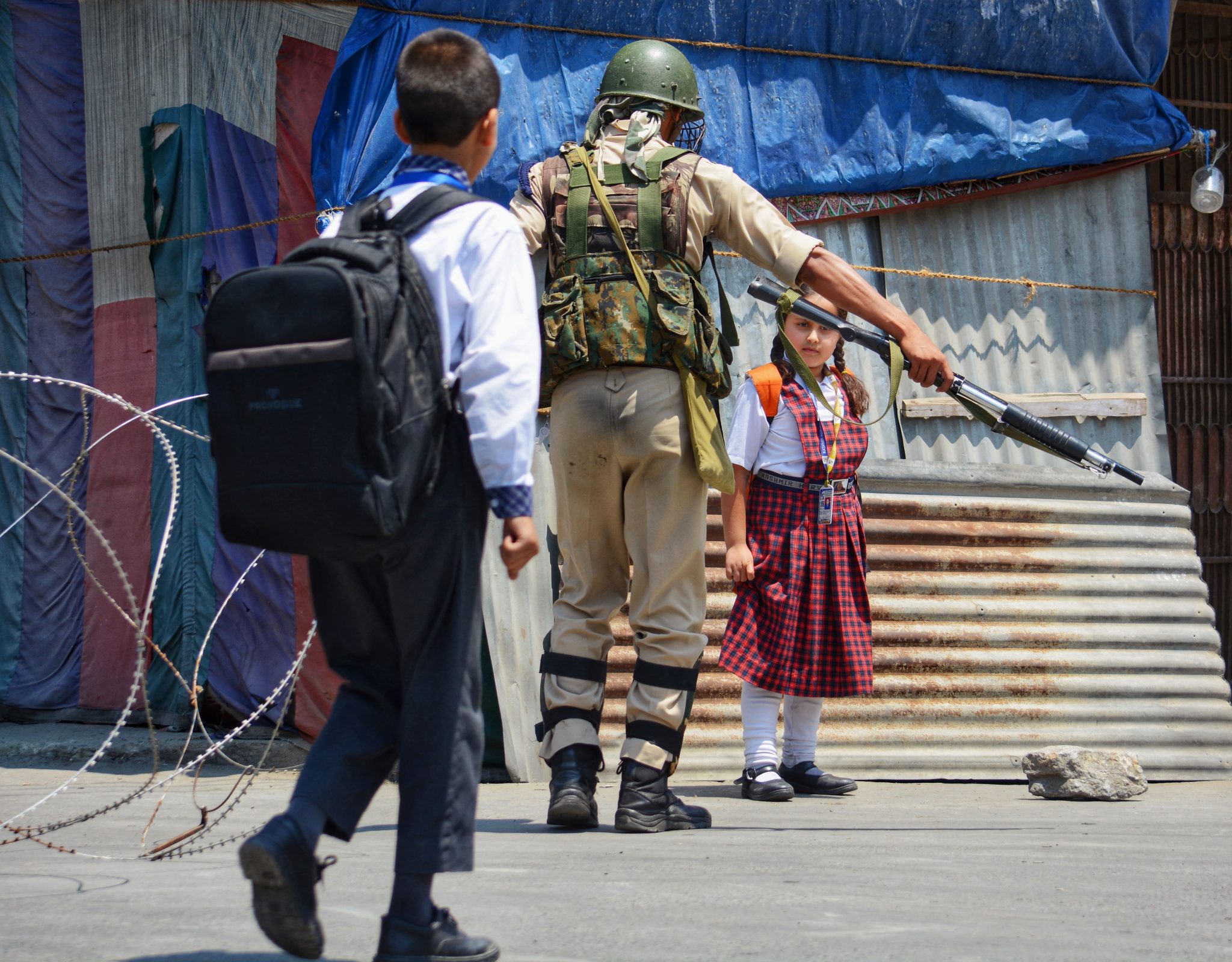 Aug.17, 2017, Razai Kadal, Srinagar, Kashmir — An Indian army soldier directs schoolchildren
to take another route during restrictions imposed by the Indian government on civilian movement.