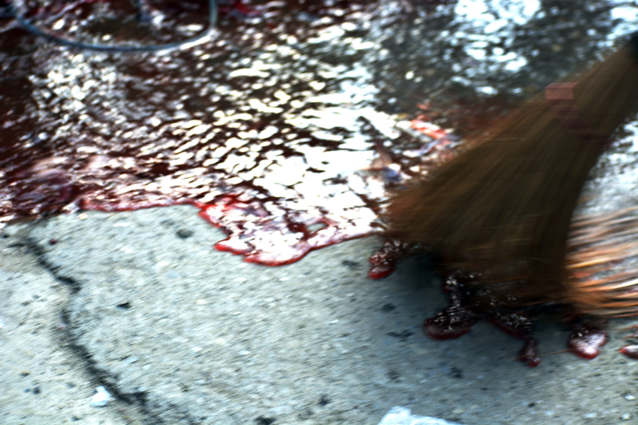 Nov. 4, 2019, Srinagar, Kashmir — Kashmiri people wash blood from the street near the site of a grenade explosion at a busy market that left two civilians dead and dozens injured.