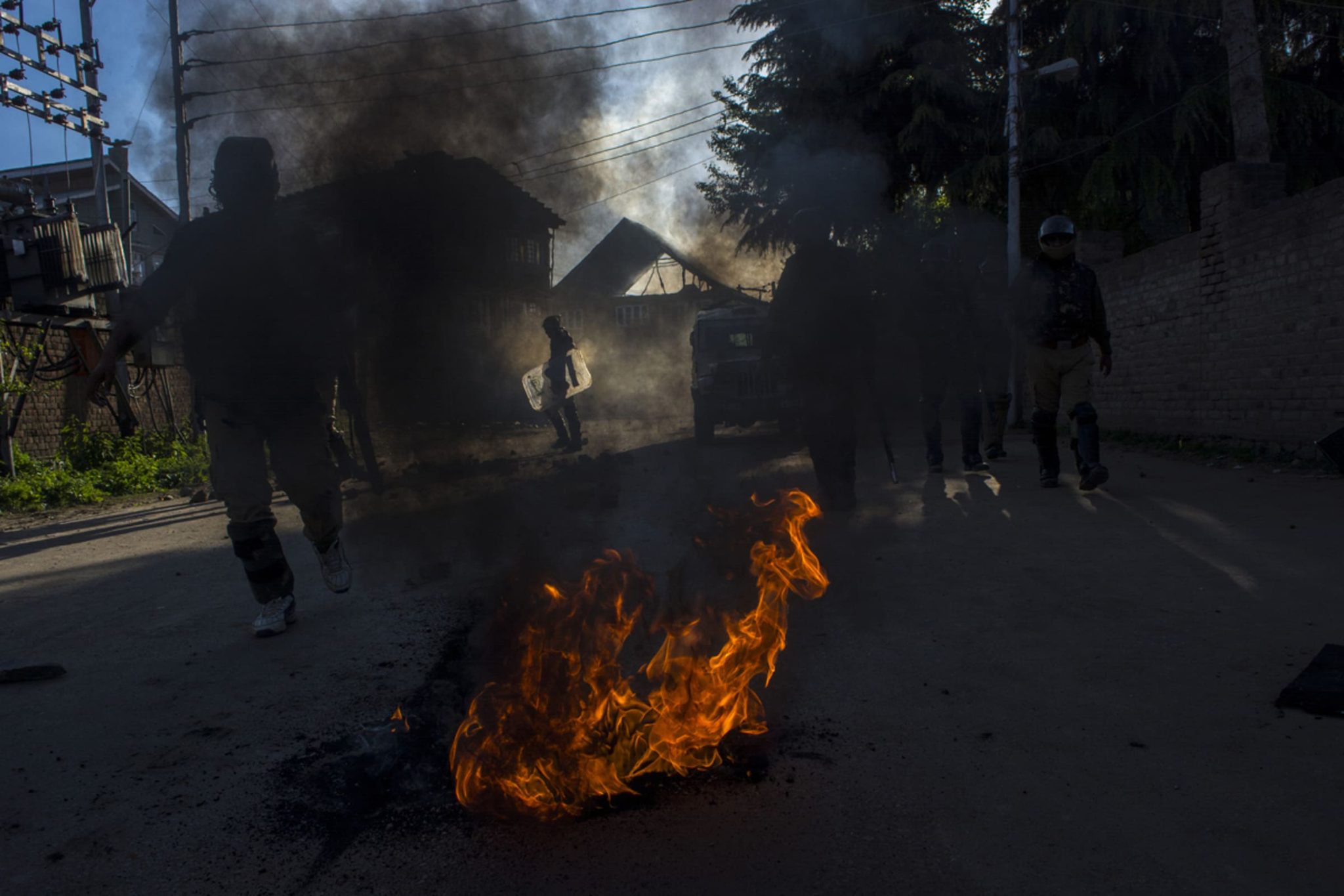 April 13, 2018, Srinagar, Kashmir — An Indian army soldier walks past a burning tire
left by protesters during a demonstration against recent killings in the valley.