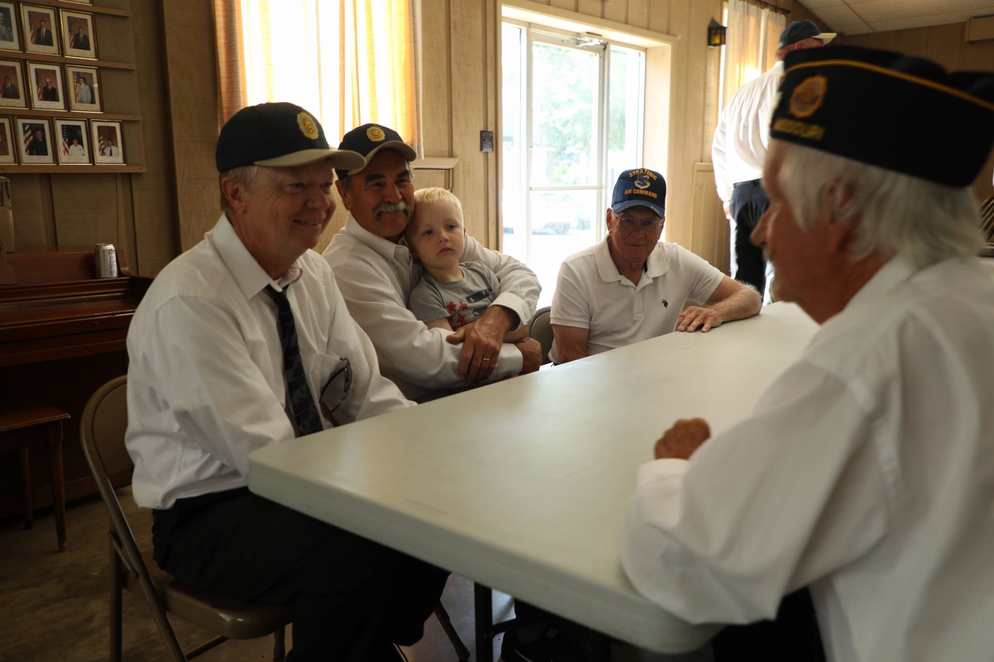 May 27, 2024, Hartsburg, Missouri — Left to right, Rick Hilgedick, Edwin Nichols with his grandson Felix Hahn, and Alan Volkart join Loyd Berry (right) during the Memorial Day celebration hosted by Hartsburg American Legion Post 424.